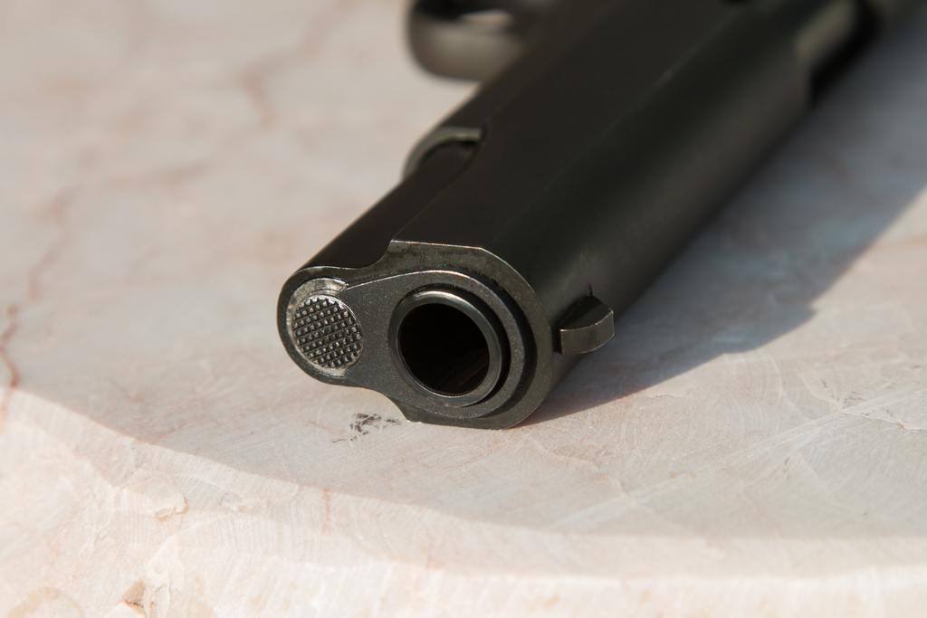 Black handgun laid flat on a marble countertop