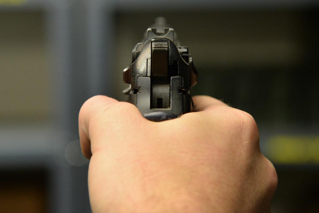 Close up of a man's hand holding a handgun