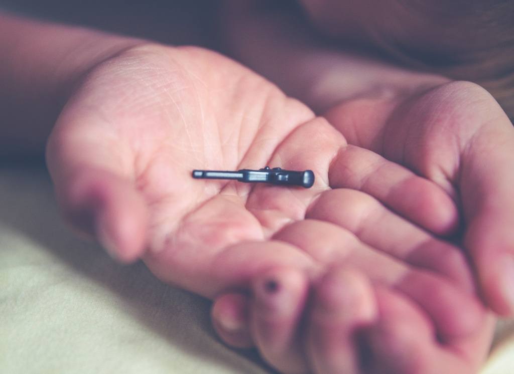 Young boy holding out a small gun toy