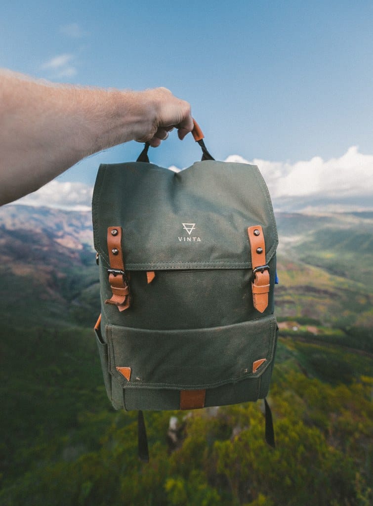 A man holding a backpack in the air