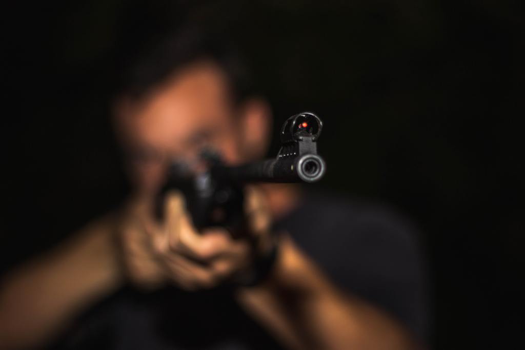 A soft focused photo of a man holding a rifle