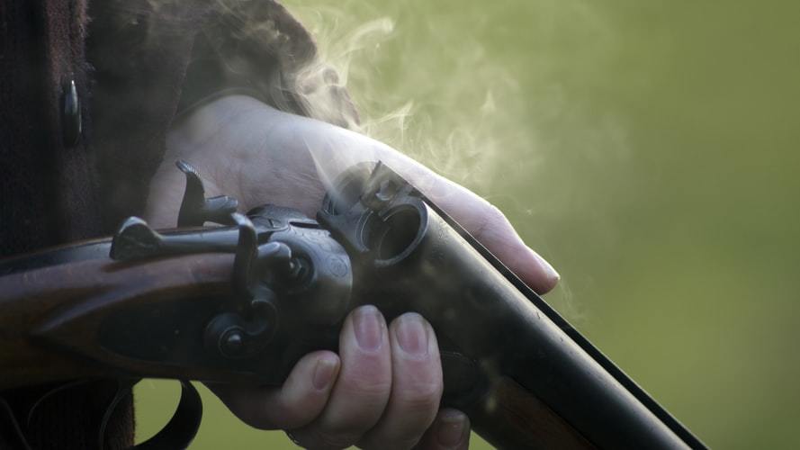 Person checking his gun after firing it at a gun range 