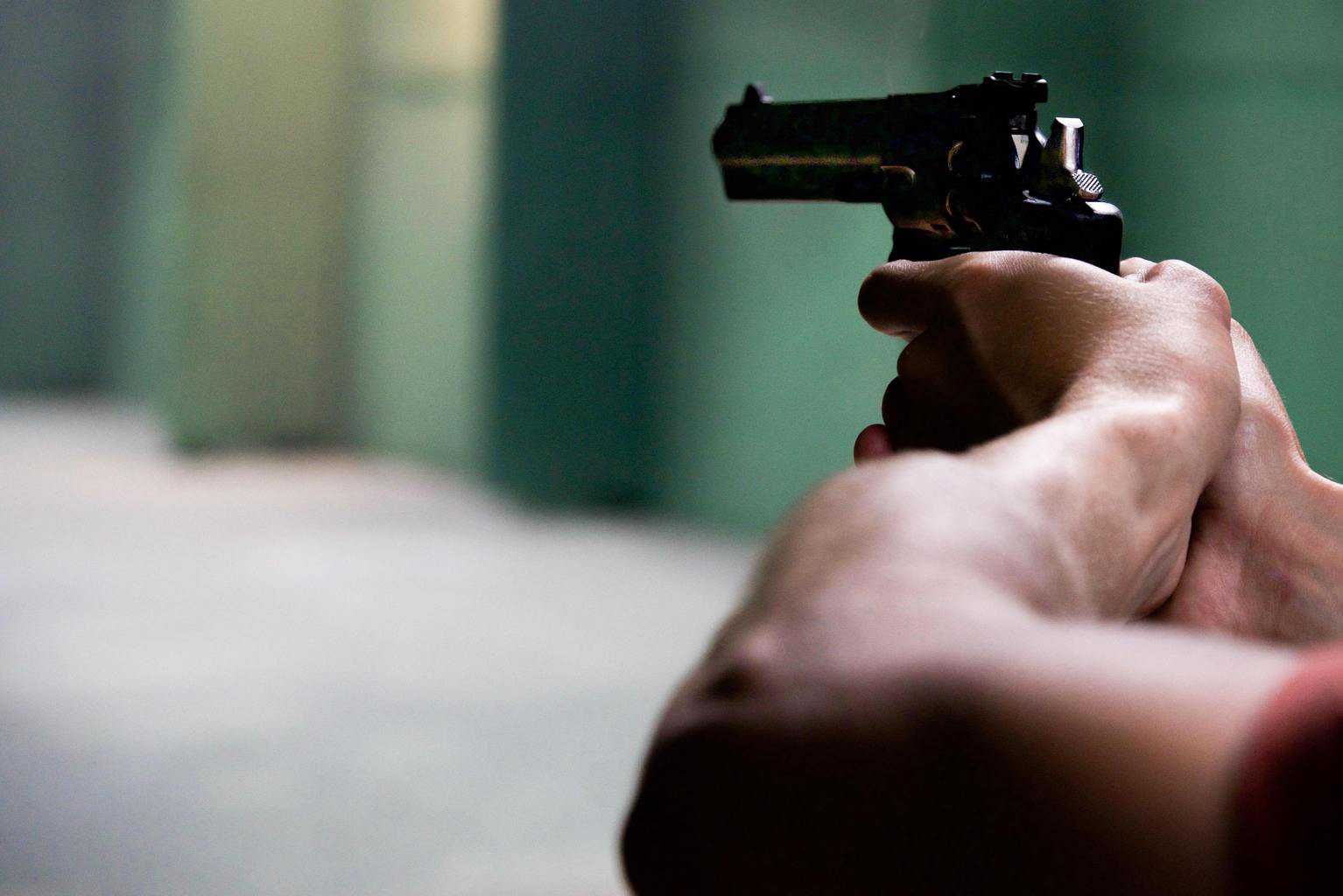 Person holding a gun at a gun range