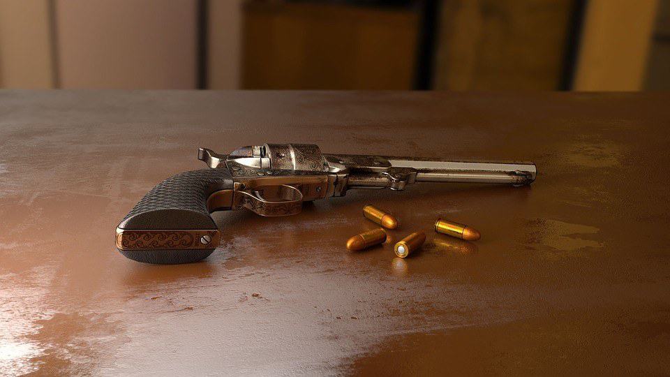 Handgun and bullets on wooden table