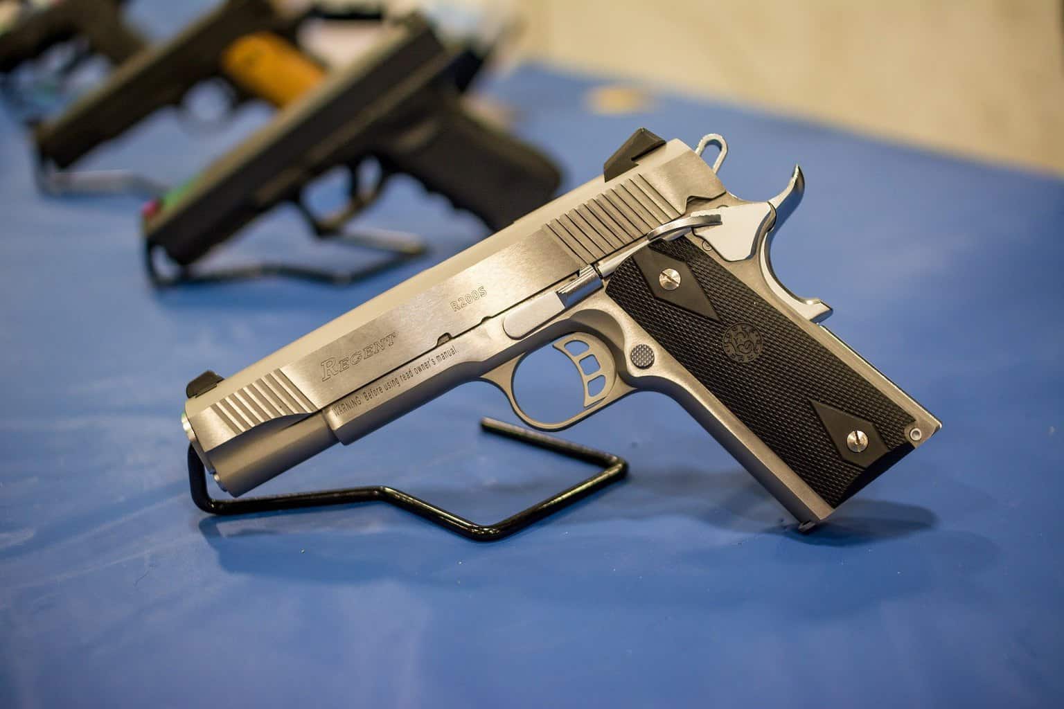 A row of handguns placed on a table