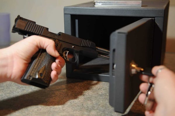 Person storing a gun in a gun safe