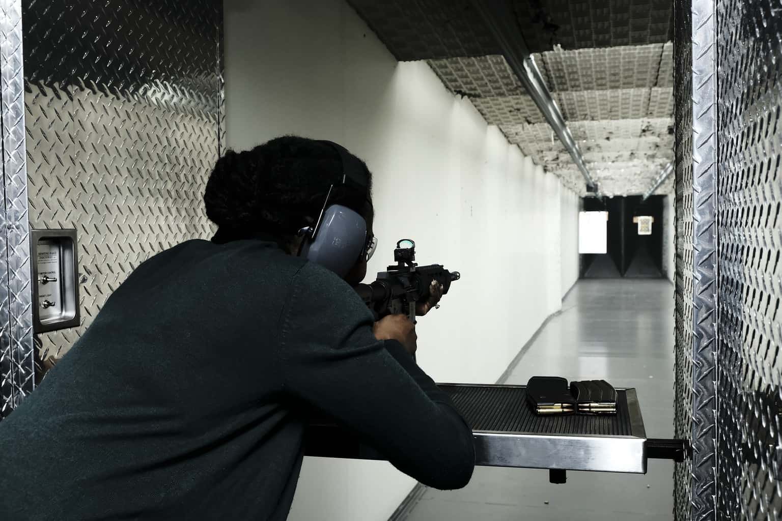Woman aiming her rifle in a shooting range