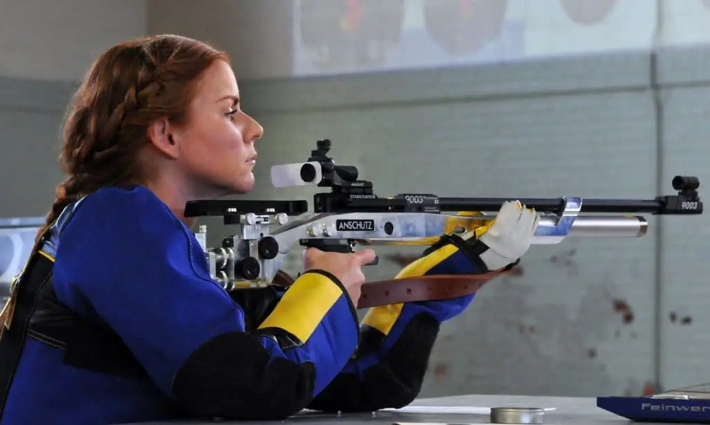 Woman holding a rifle at an indoor gun range