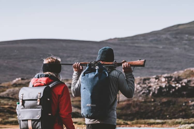 Couple with their backpacks while hunting outdoors