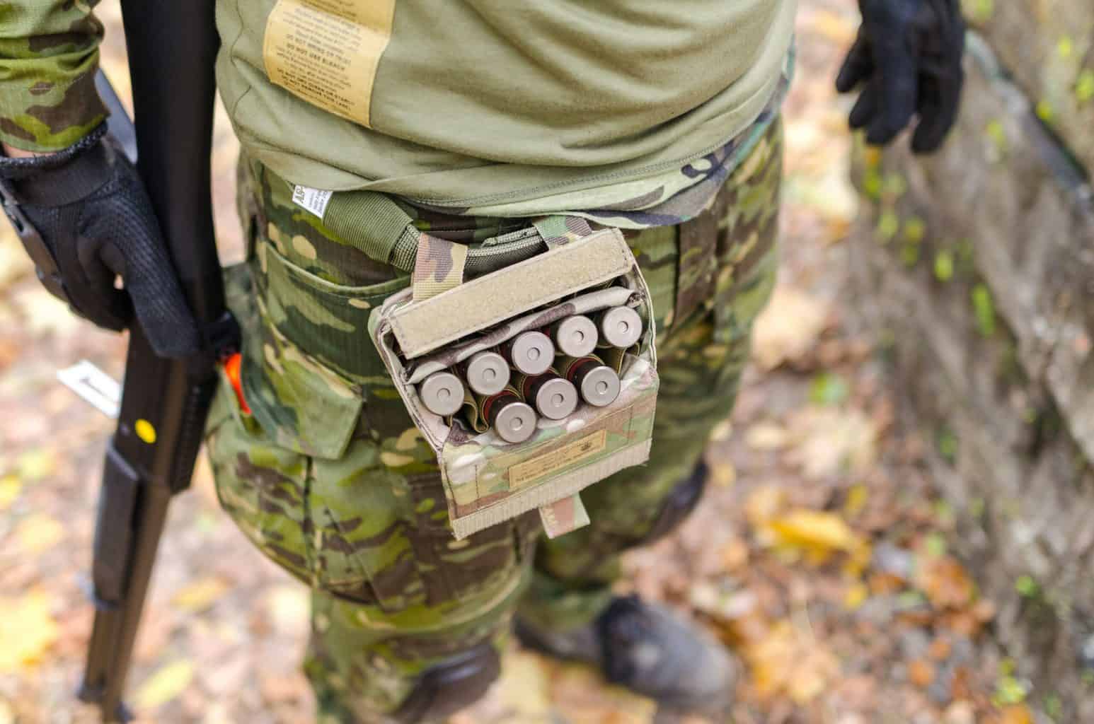 Person wearing an ammo kit on his waist for reloading while holding a shotgun