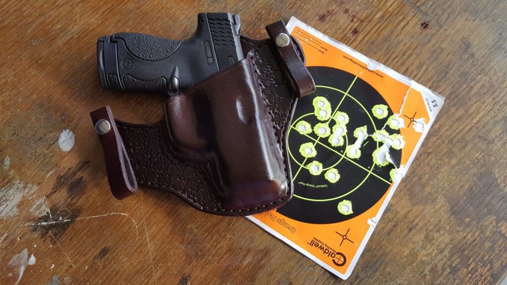 Handgun and used target paper on a table