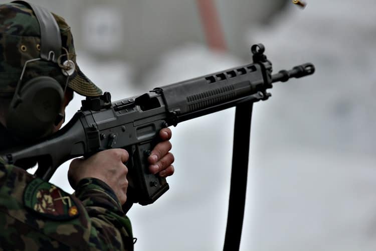 Person aiming and holding a gun at a target