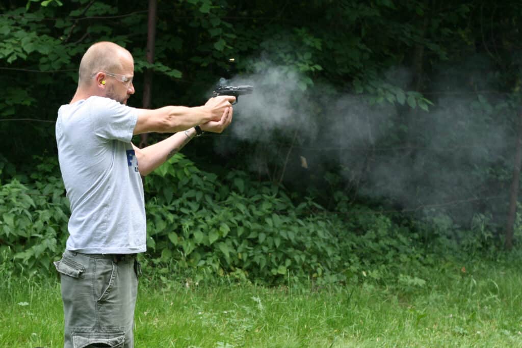 Man firing a gun at a shooting range in Kansas