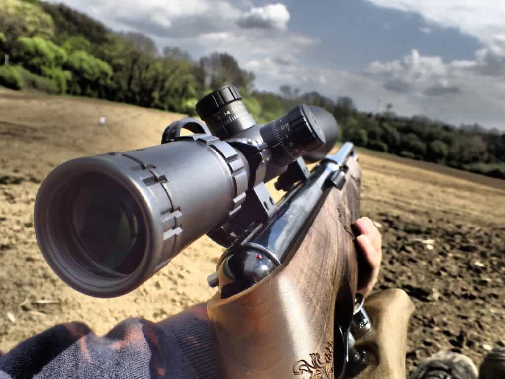 Person holding a rifle outdoors