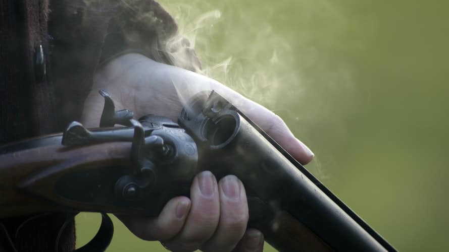 Person holding a freshly fired rifle