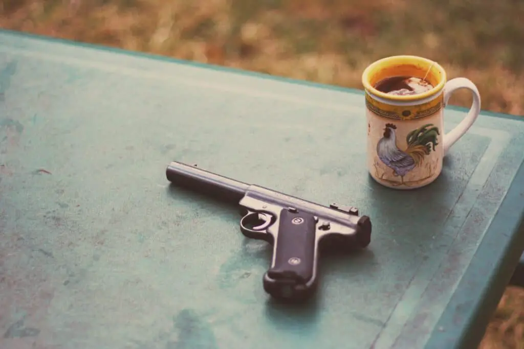 Handgun and a mug of tea on a table