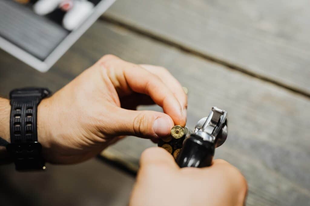 Man loading his pistol with a bullet