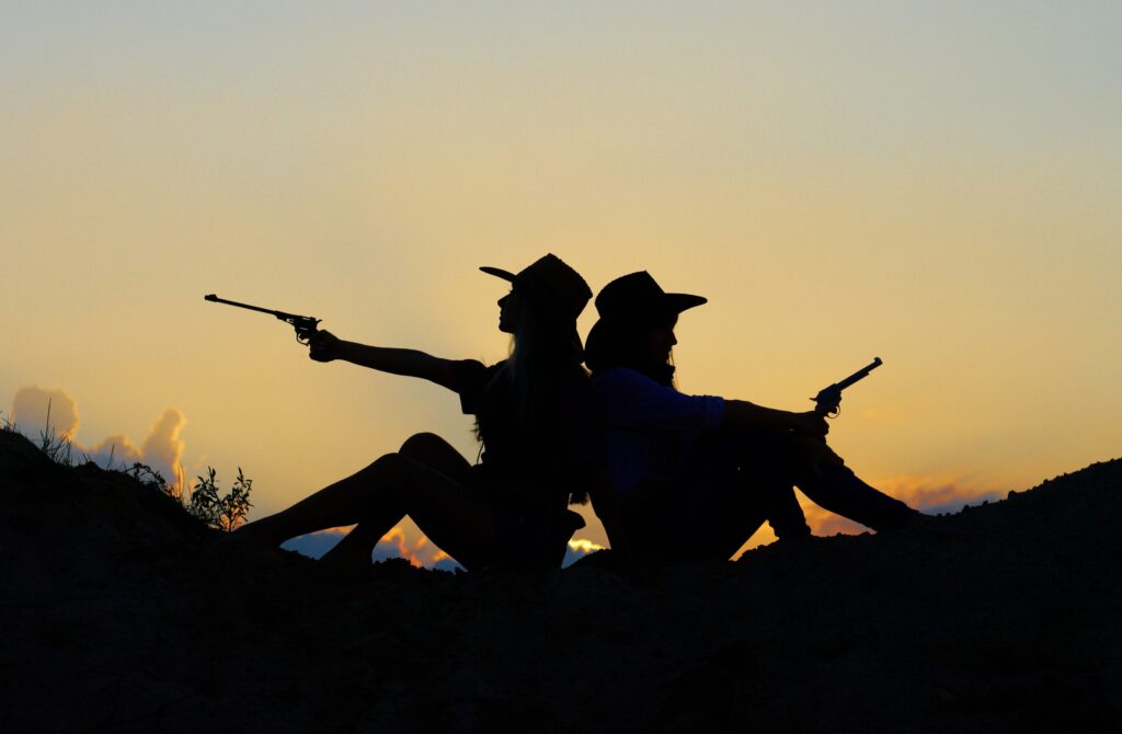 a silhouette of two people holding a gun