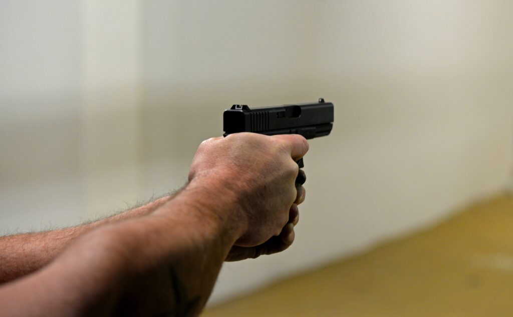 man firing a pistol in shooting range