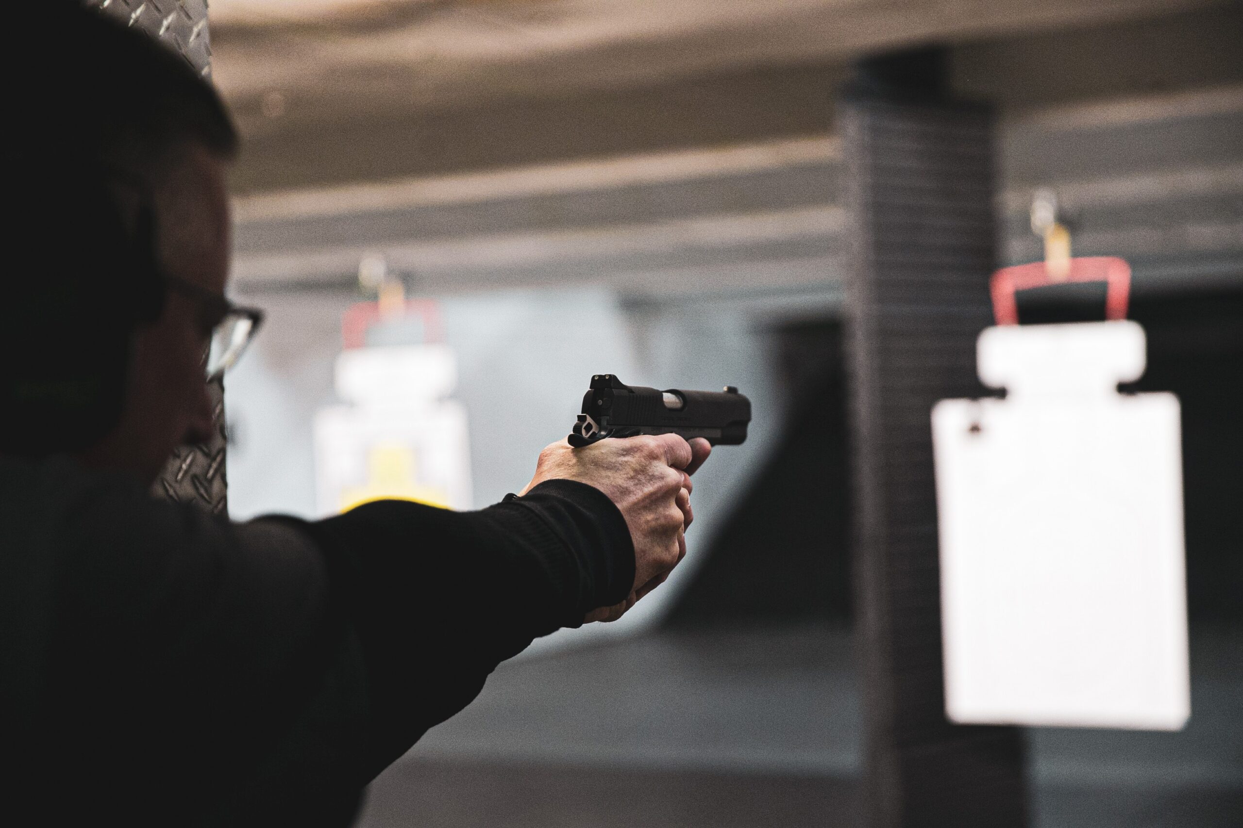 man shooting at a target paper in a shooting range