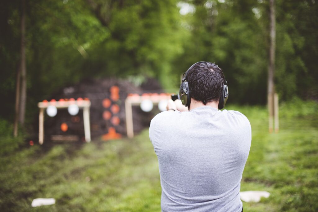 male shooting a gun at a gun range