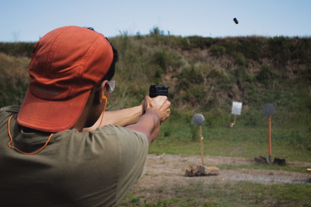 guy shooting gun in an open area