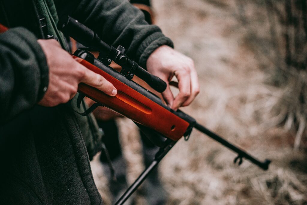 person holding a rifle pointing downwards