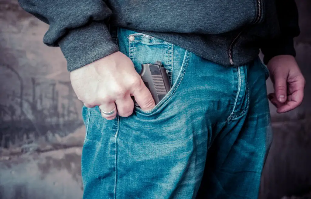 man carrying a gun in his pocket