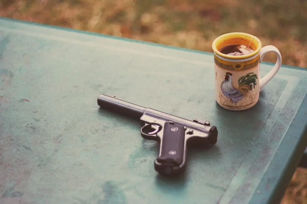 Pistol and a cup of coffee on top of a table