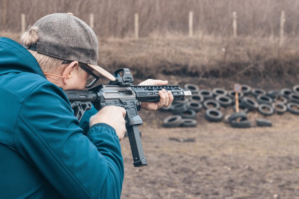 Guy wearing blue jacket shooting a machine gun