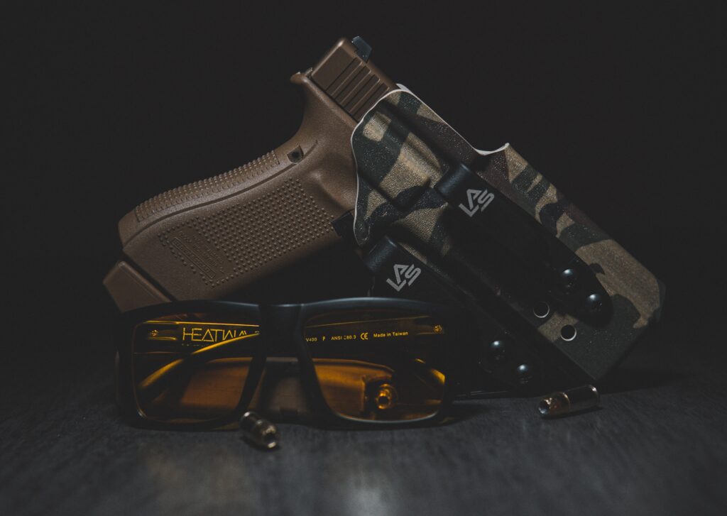 A brown handgun with protective glasses