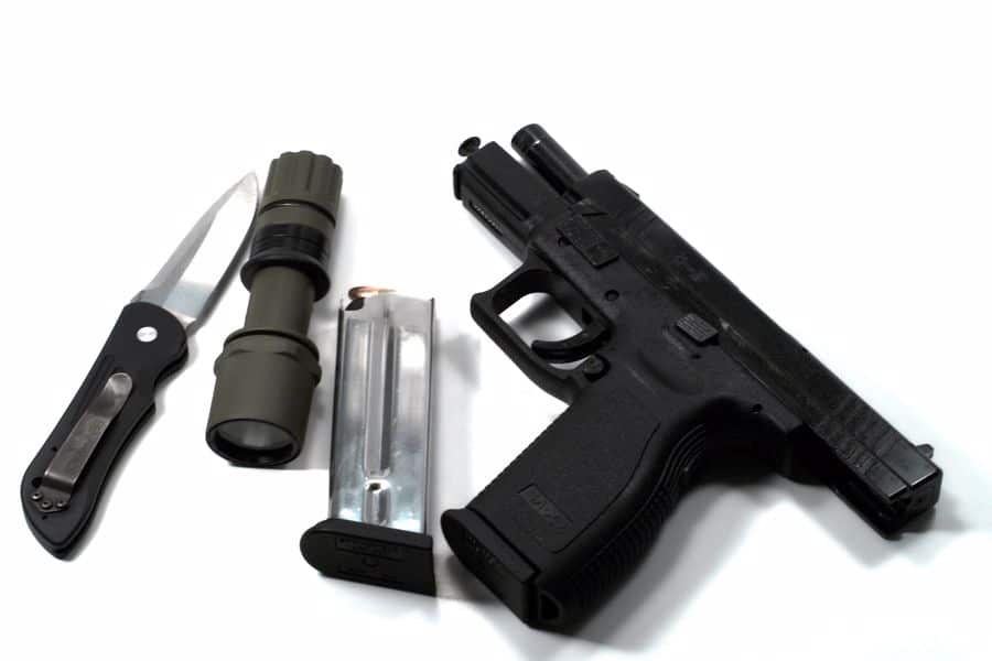 Handgun, knife, and gun accessories on a table