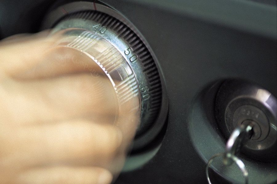 Hand trying to open a combination lock