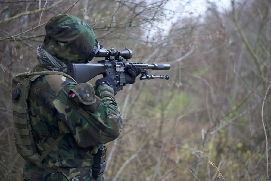 Man looking at his rifle scope