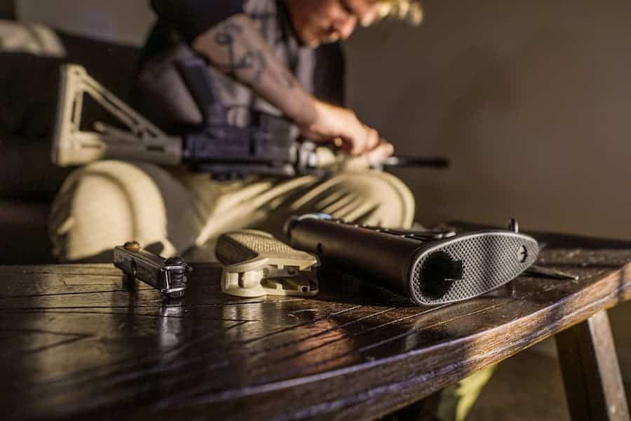 A man dissembles his AR 15 rifle.