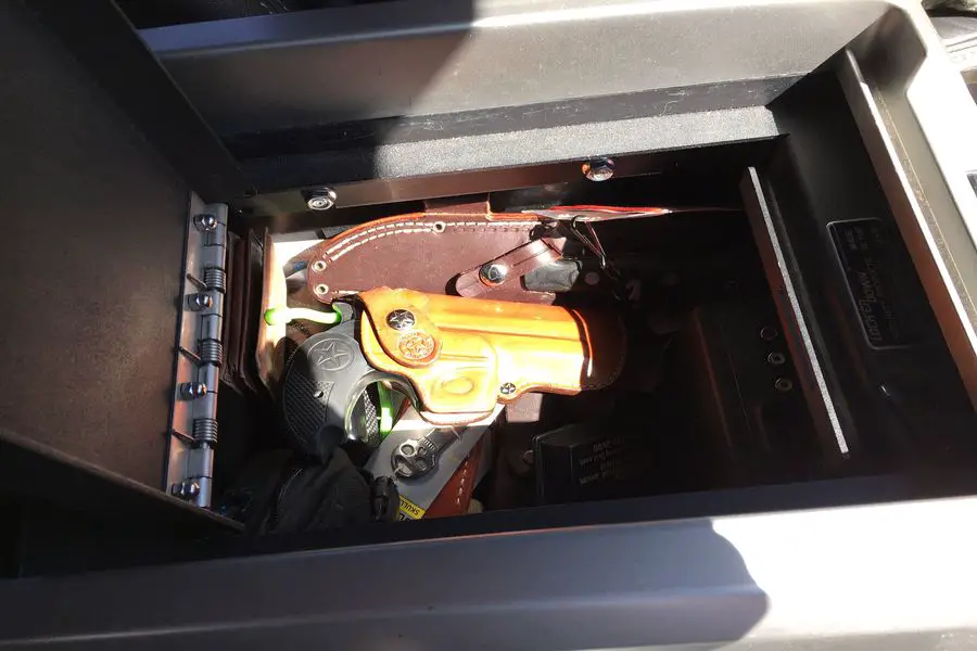 Guns and accessories stored in a car console safe