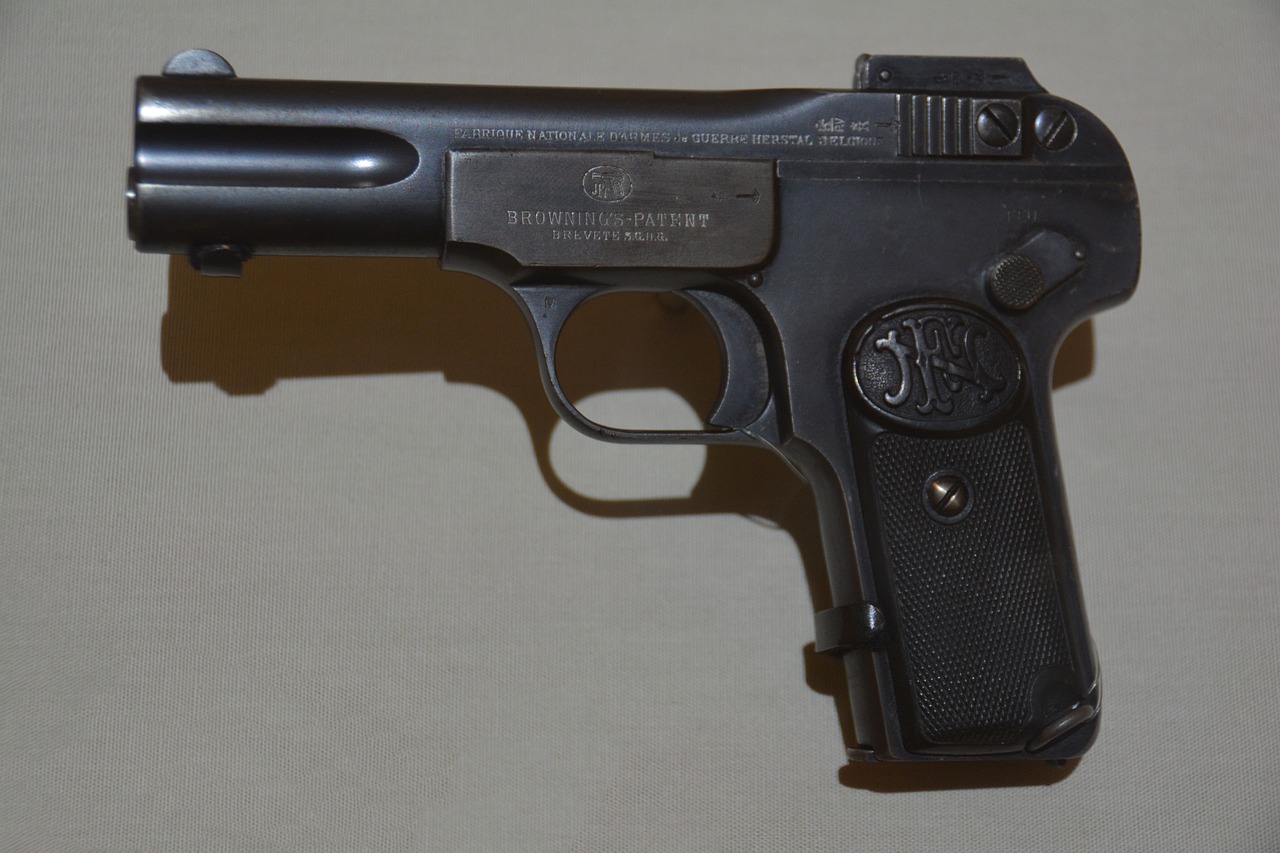A close-up black pistol handgun placed on a white surface