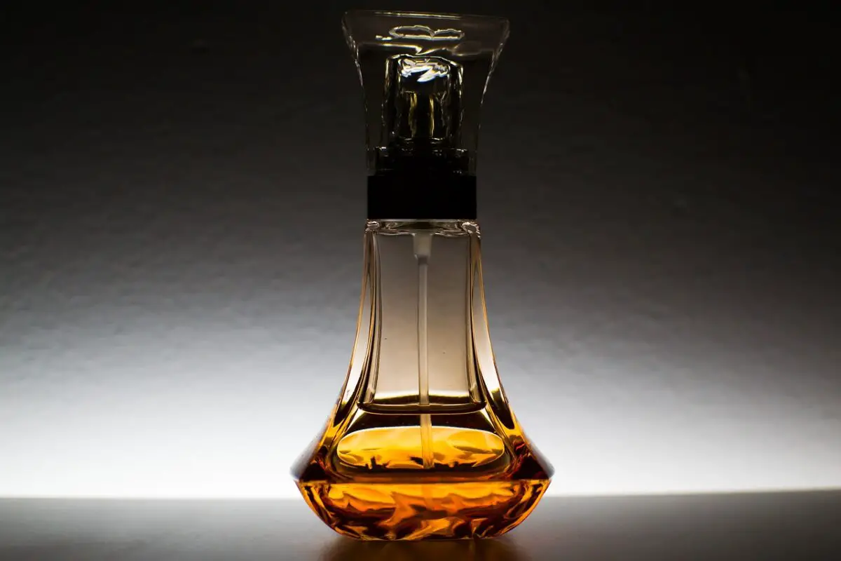 Oil is placed on a clear bottle with a clear cap on a black surface