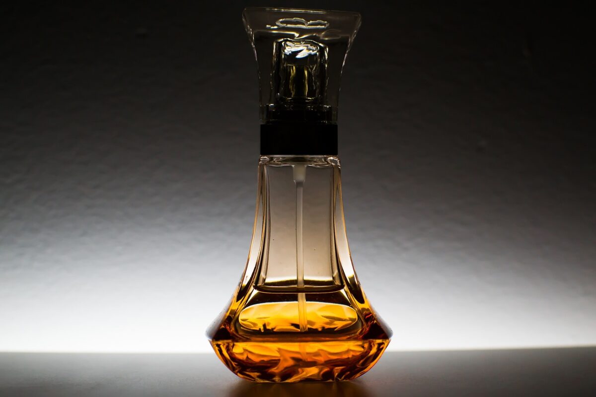 Oil is placed on a clear bottle with a clear cap on a black surface